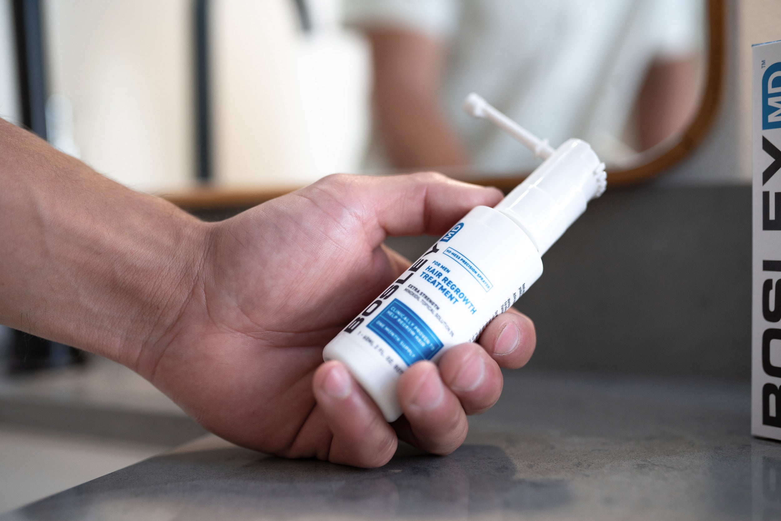 Bosley MD Men's Minoxidil Product Display Hand Holding Bottle